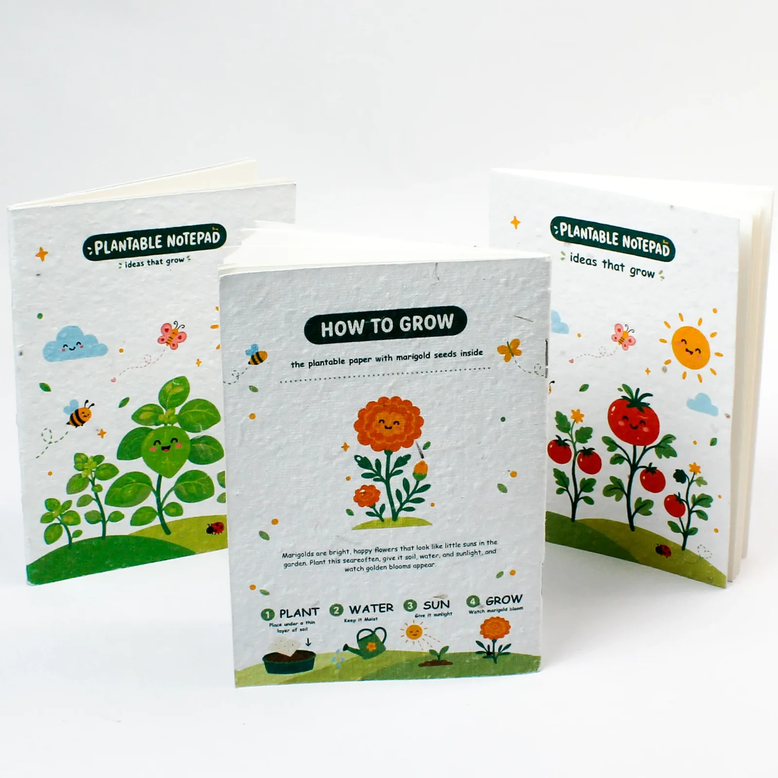 Three centre-pinned notepads with the illustrated planting-instruction panel turned towards the camera