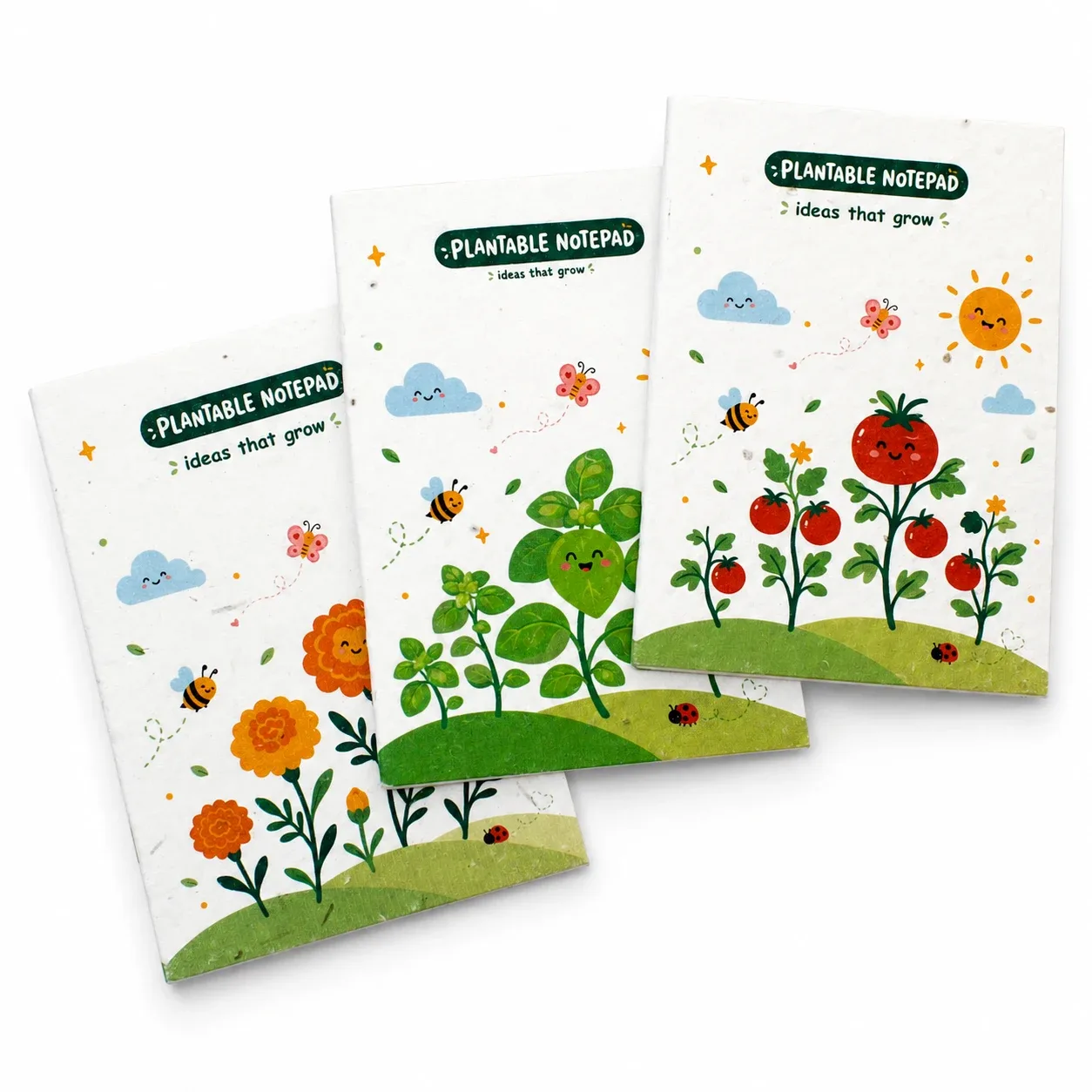 Three illustrated seed-paper notepad covers with orange flowers, green leaves and tomato plants