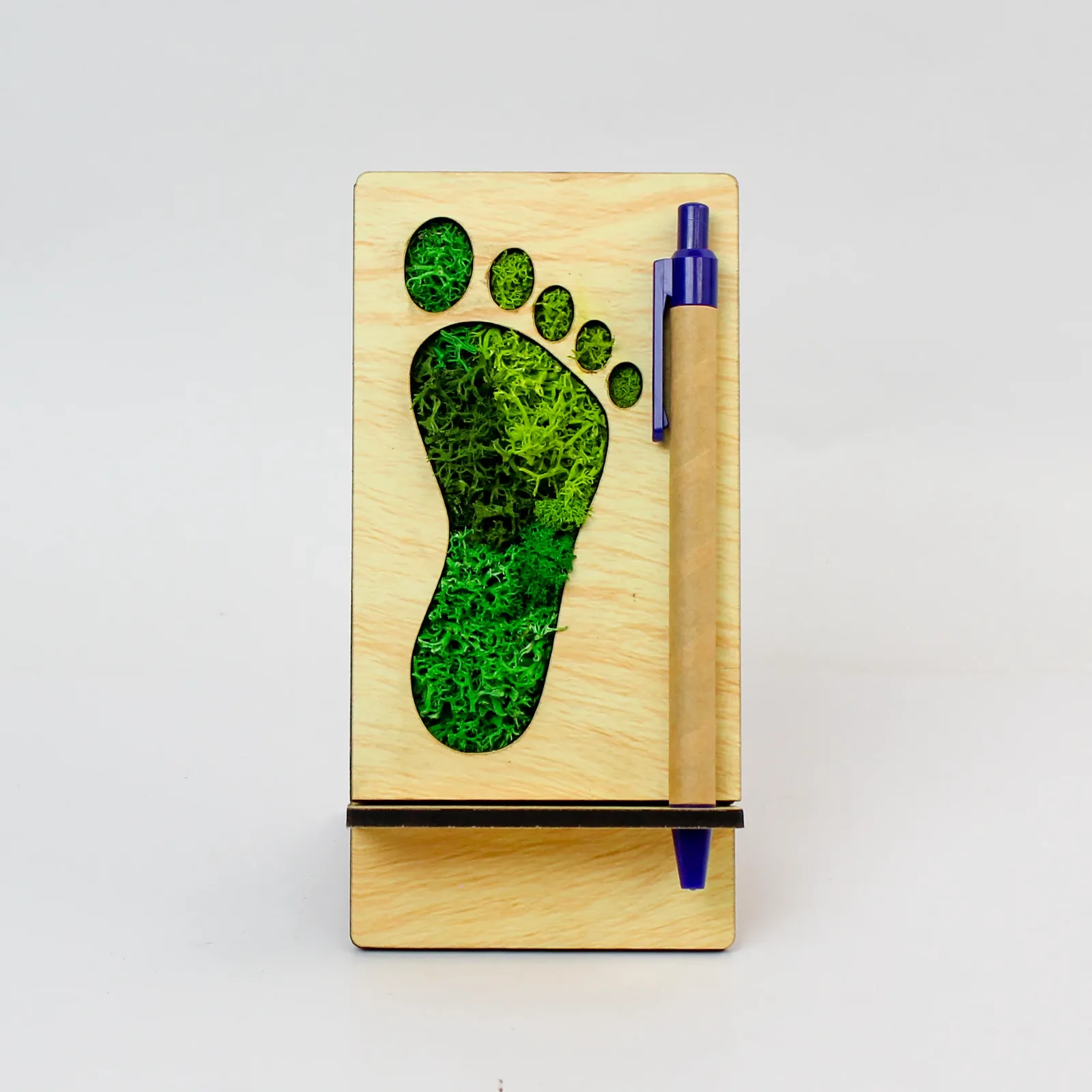 Front view of the three-inch MDF Footprint Forest Pen Stand with its moss inlay and included blue paper click pen